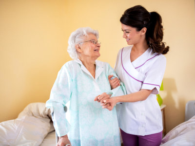 caregiver holding senior woman and smiling