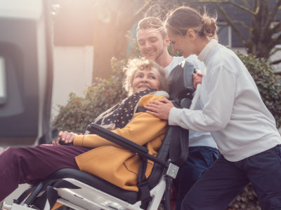 caregivers pushing the senior woman's wheelchair